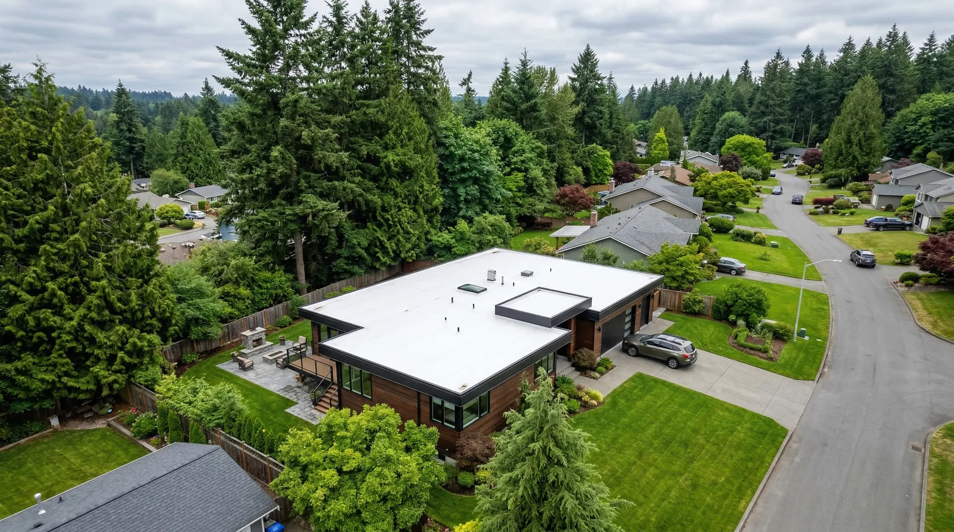 Modern home with white TPO membrane flat roof in Pacific Northwest neighborhood